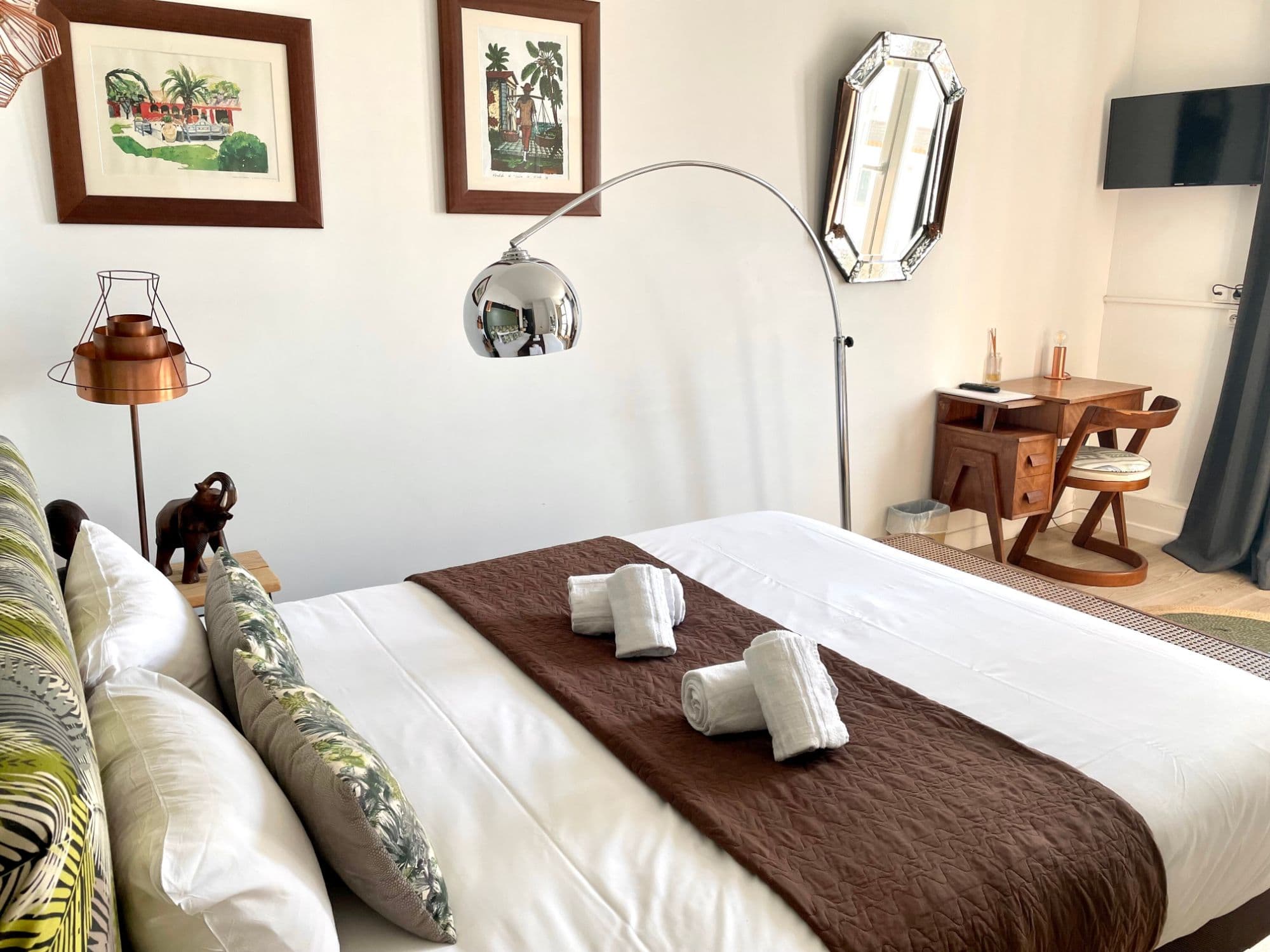 Chambre double au mobilier vintage, coussins à motifs tropicaux